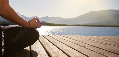 Detail of woman's hand meditating in front of sea