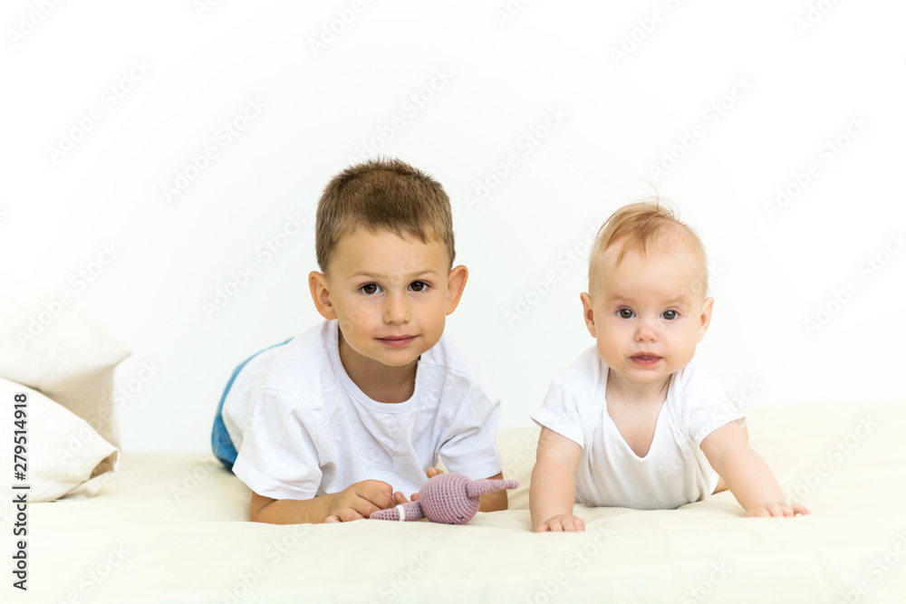 Portrait of brother and sister. Two cute children lying on bed Portrait of brother and sister. Two cute children lying on bed