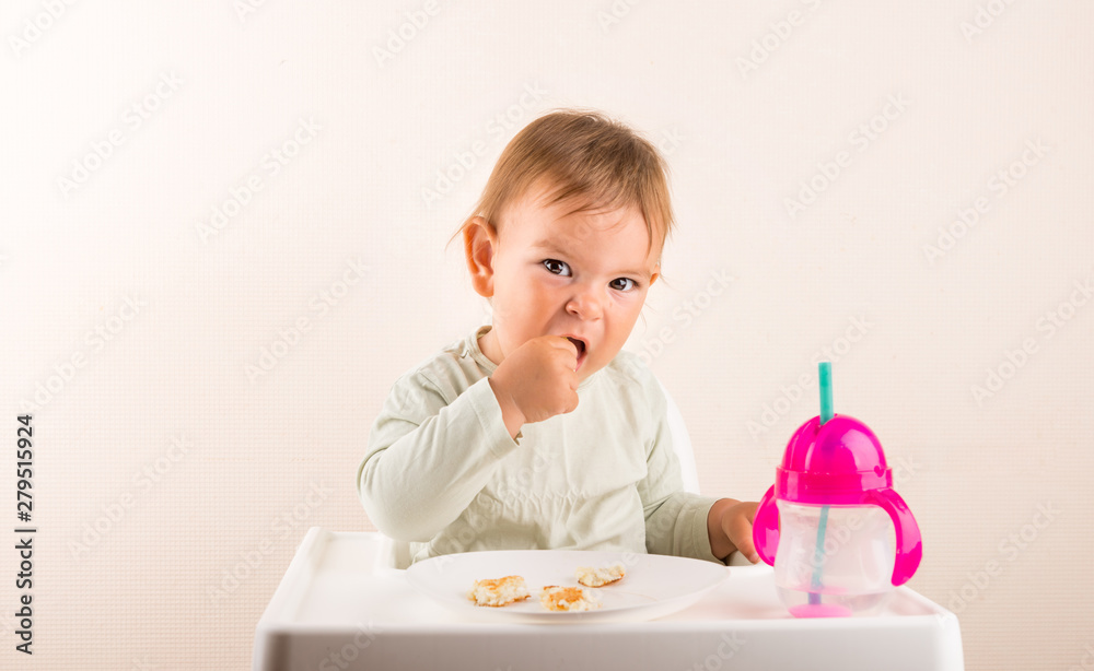 Baby toddler eats food with fingers. Fun face. Copy space Baby toddler eats food with fingers. Fun face. Copy space