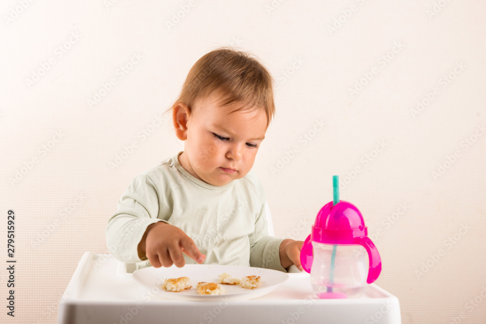 Baby toddler eats food with fingers. Fun face. Copy space Baby toddler eats food with fingers. Fun face. Copy space