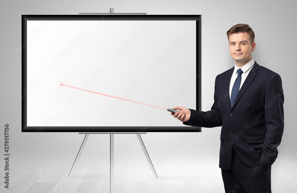 Young businessman with laser pointer and copyspace white wall Young businessman with laser pointer and copyspace white wall