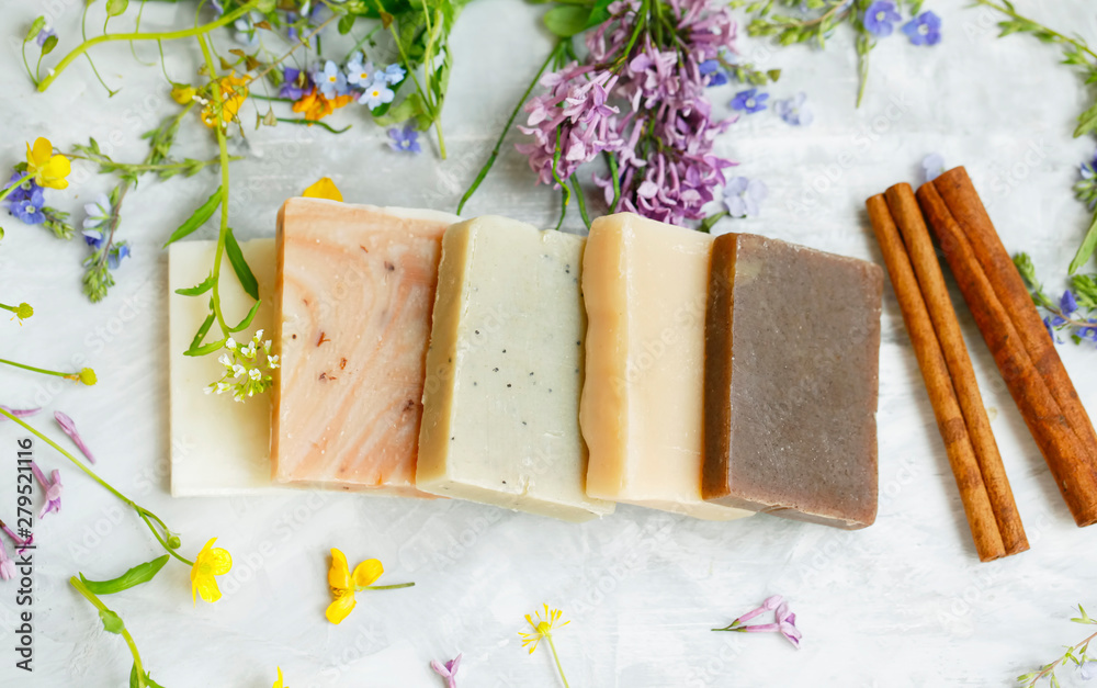 Natural handmade soap bars with organic medicinal plants and flowers.Homemade beauty products with natural essential oils from plants and flowers, top view closeup photo - obrazy, fototapety, plakaty 