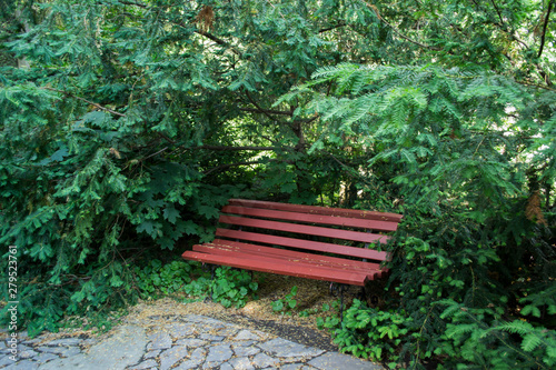 The red wooden bench in the park.