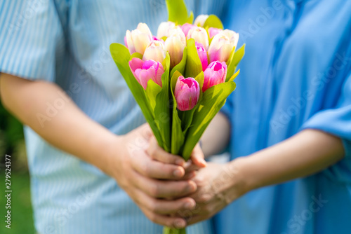 Middle aged couple hold flower together ingreen park photo