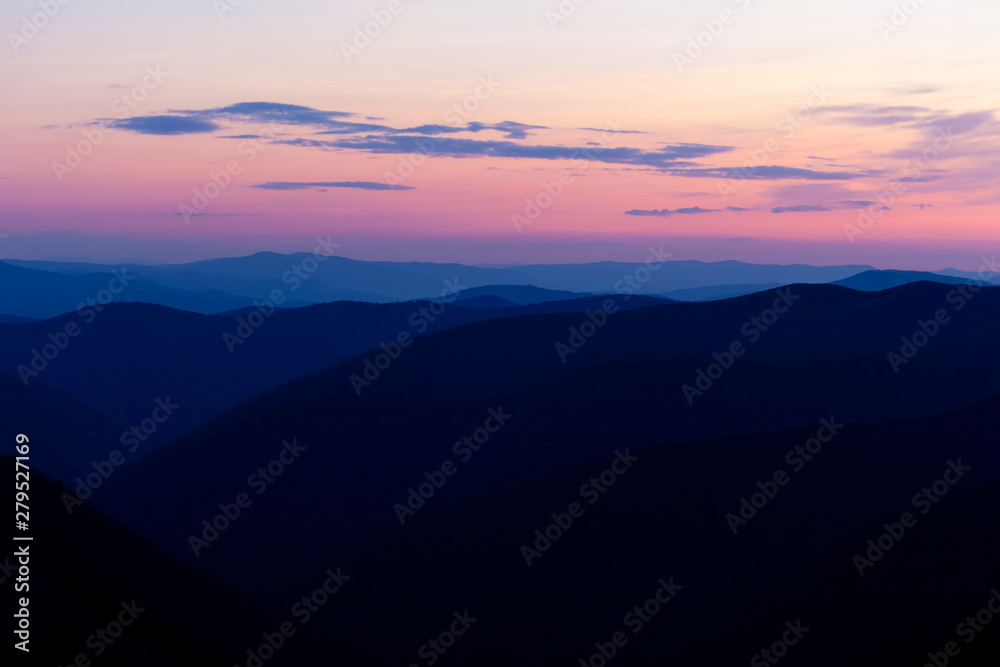 Majestic sunset in the mountains landscape. Beautiful landscape with high mountains blue sky and pink sunlight in sunset. Carpathian Mountains.