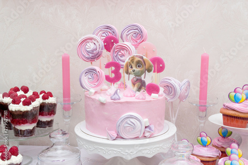 Сake with Paw Patrol character and cupcakes on the birthday of a little princess. Canadian animated television series created by Keith Chapman. photo