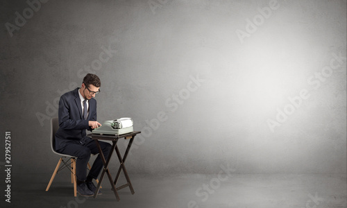 Man working hard on a typewriter in an empty space photo