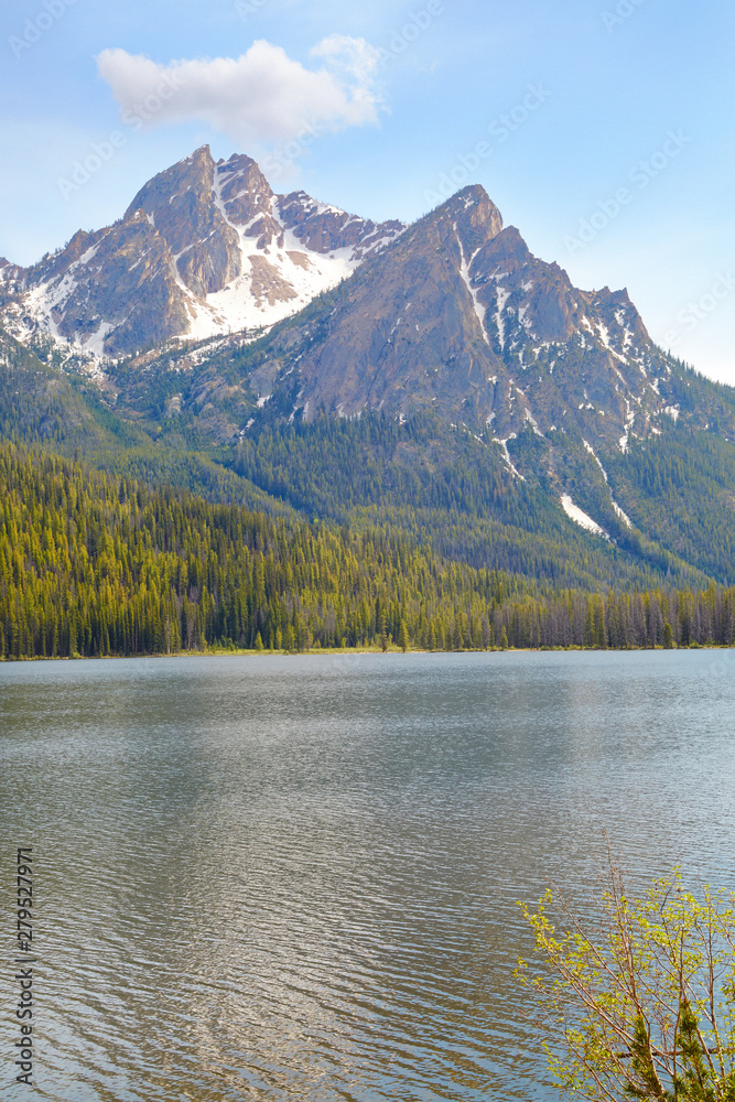 Mountain peaks rising from a glacier lake and forest in Sawtooth Mts in Idaho