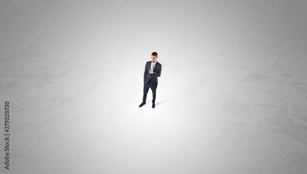 Young businessman standing alone in the middle of an empty space Young businessman standing alone in the middle of an empty space
