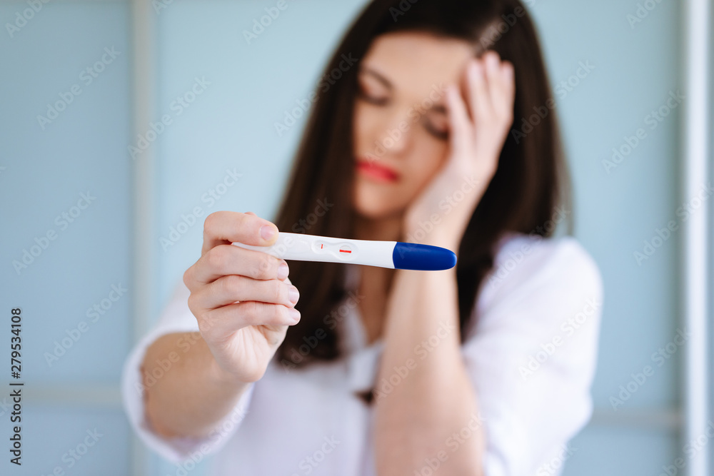 Young woman shocked to see a positive pregnancy test Young woman shocked to see a positive pregnancy test