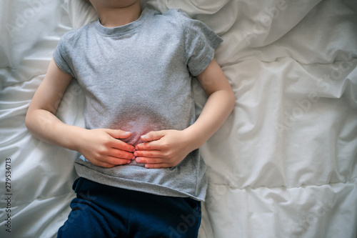 abdominal pain in a preschool child. poisoning in children. the boy holds his hands to the abdominal cavity