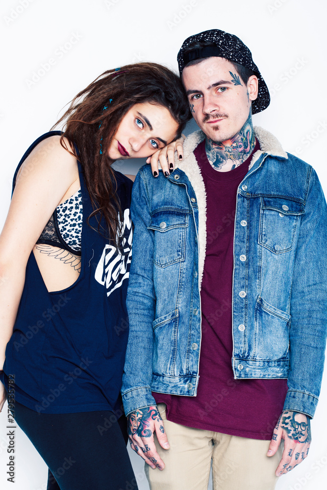 Young couple together. guy with tattoo, girlfriend wearing dreadlocks having fun on white background Young couple together. guy with tattoo, girlfriend wearing dreadlocks having fun on white background