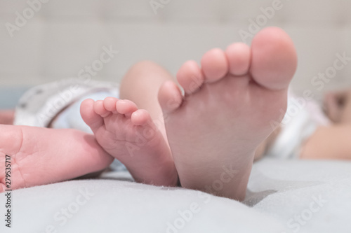 Baby feet lying and resting while sleeping on a bed