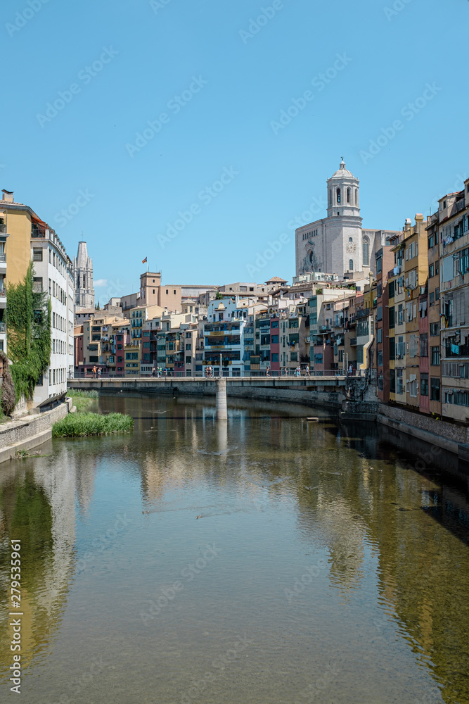 Girona's skyline with cathedral and bridge over the river landmarks on a blue Sunny day