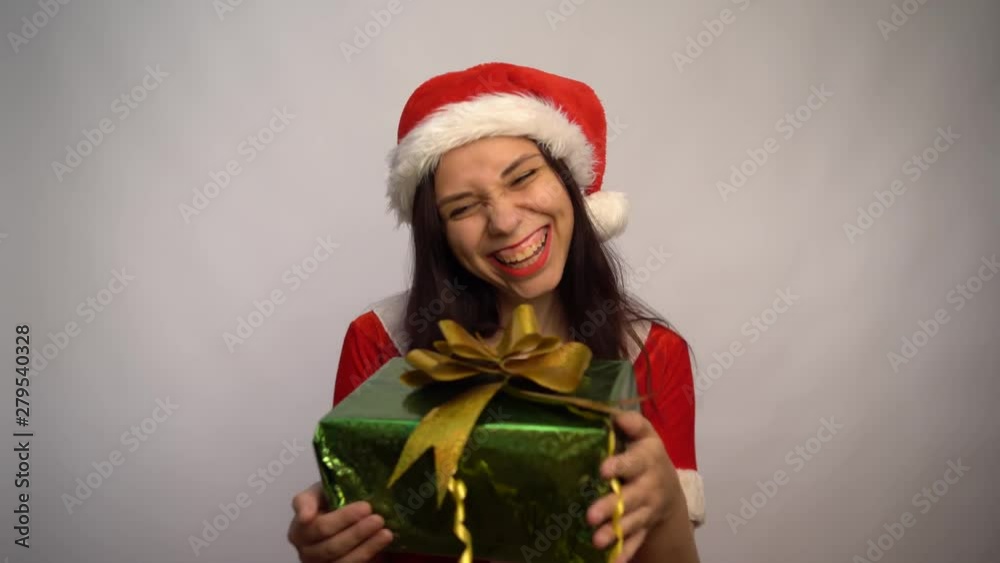 Smiling beautiful young woman in Santa Claus suit is holding gifts on a white background. Merry Christmas and Happy New Year. Smiling beautiful young woman in Santa Claus suit is holding gifts on a white background. Merry Christmas and Happy New Year.