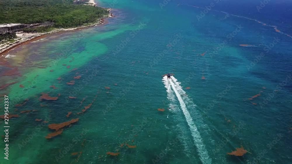 Cinematic Aerial Tilt Up From Carribean Sea to Speadboat Sailing By Coast in Xcaret, Beach Resorts Area in Mexico Cinematic Aerial Tilt Up From Carribean Sea to Speadboat Sailing By Coast in Xcaret, Beach Resorts Area in Mexico