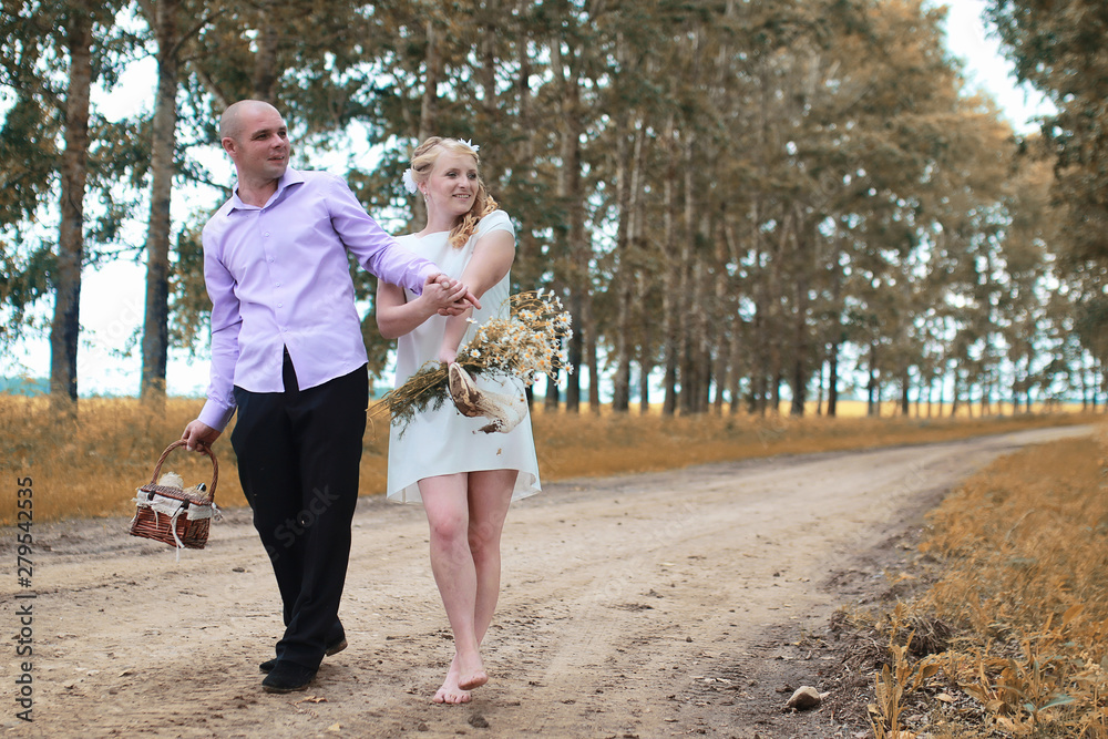 Fototapeta premium Just married lovers walking in a field in autumn day