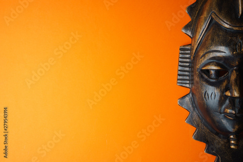 Wooden african mask on orange background photo