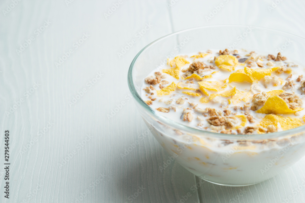 Glass bowl of cornflakes and milk Glass bowl of cornflakes and milk