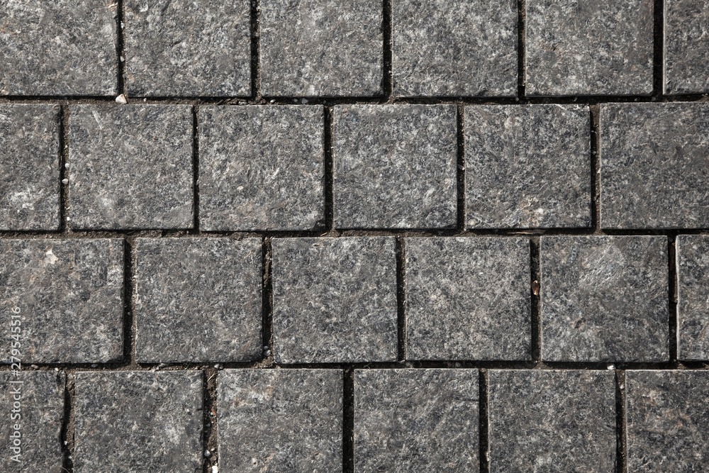 Abstract background of gray cobblestone pavement,close-up, top view.