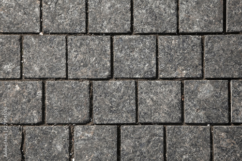Abstract background of gray cobblestone pavement close-up  top view.
