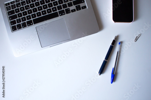 Laptop, phone and pens on white background
