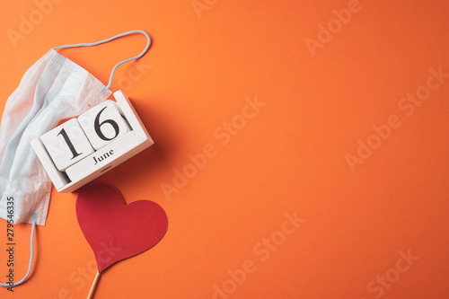 June 16, Day of the Medical Worker in Russia, wooden calendar on an orange background, a place for an inscription, top view