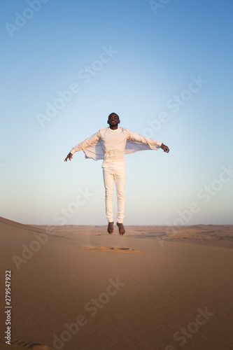 black man flies on a background of yellow desert