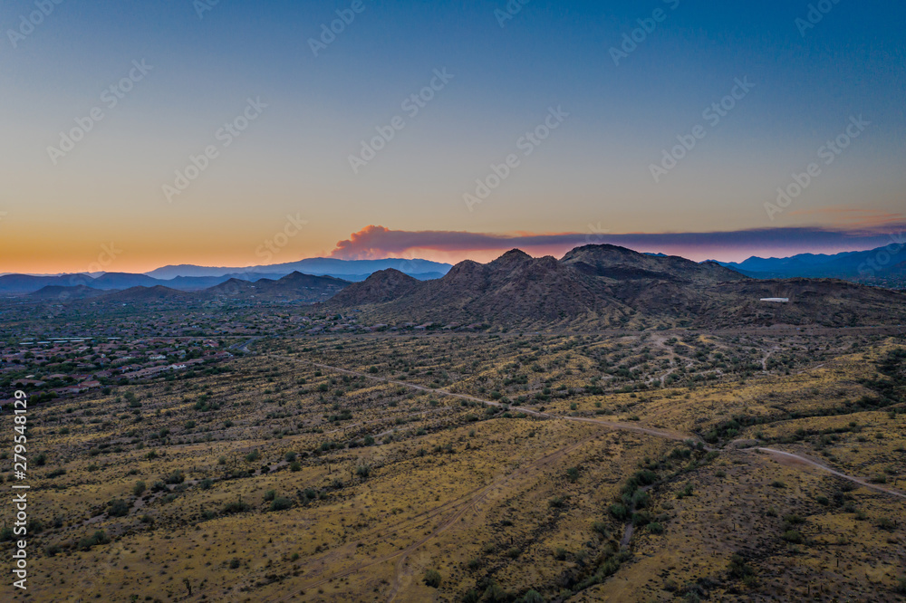 Wild fire smoke viewed from a drone as the smoke rises and catches the evening light of the setting sun.