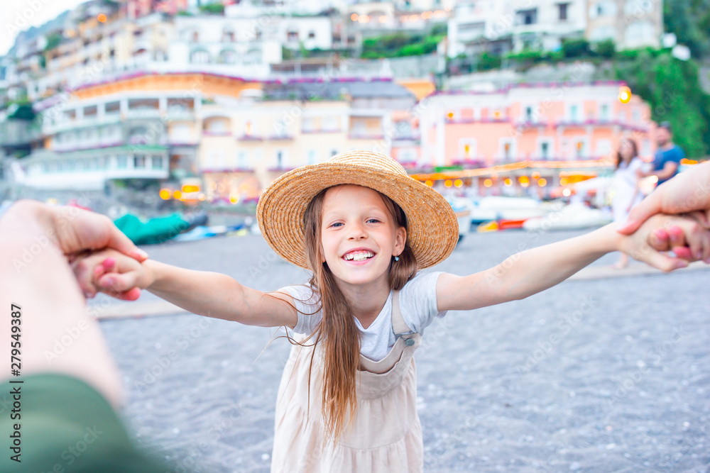 Adorable little girl on warm and sunny summer day in Positano town in Italy