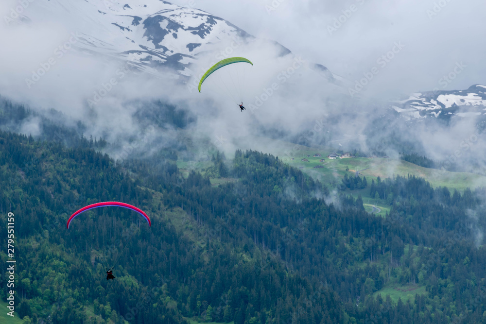 Two sky divers in the sky in Alps mountains, Switzerland Two sky divers in the sky in Alps mountains, Switzerland