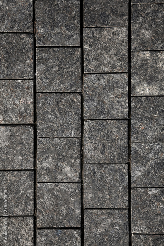 Abstract background of gray cobblestone pavement close-up  top view.