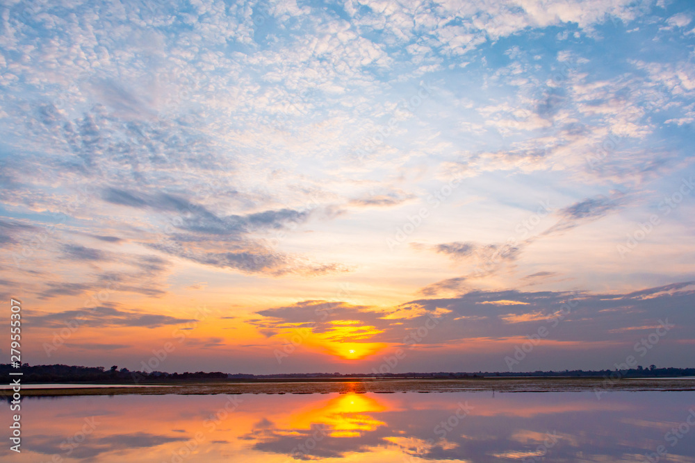 Sunset reflection lagoon. beautiful sunset behind the clouds and blue sky above the over lagoon landscape background. dramatic sky with cloud at sunset Sunset reflection lagoon. beautiful sunset behind the clouds and blue sky above the over lagoon landscape background. dramatic sky with cloud at sunset