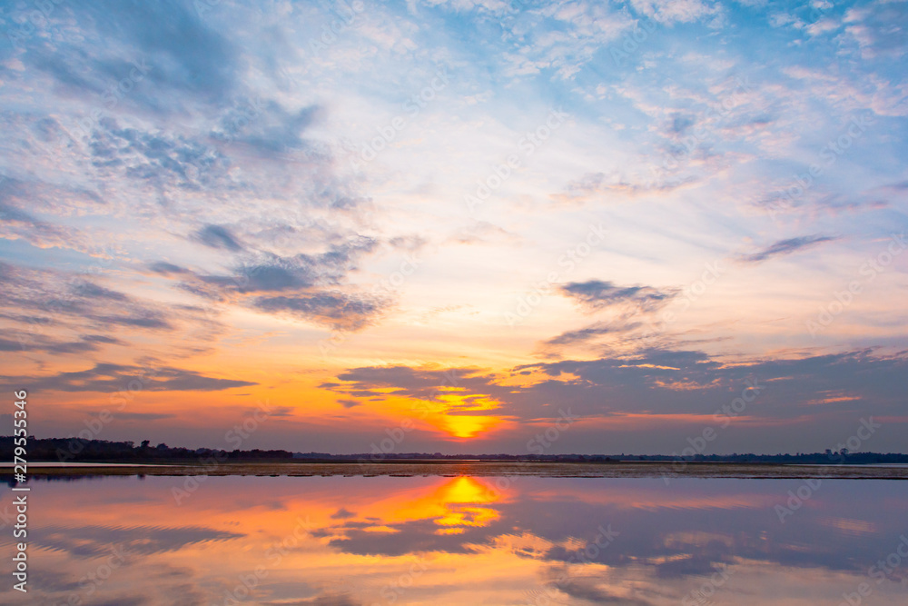 Sunset reflection lagoon. beautiful sunset behind the clouds and blue sky above the over lagoon landscape background. dramatic sky with cloud at sunset Sunset reflection lagoon. beautiful sunset behind the clouds and blue sky above the over lagoon landscape background. dramatic sky with cloud at sunset