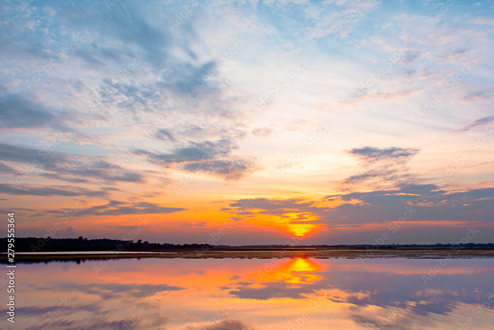 Sunset reflection lagoon. beautiful sunset behind the clouds and blue sky above the over lagoon landscape background. dramatic sky with cloud at sunset Sunset reflection lagoon. beautiful sunset behind the clouds and blue sky above the over lagoon landscape background. dramatic sky with cloud at sunset