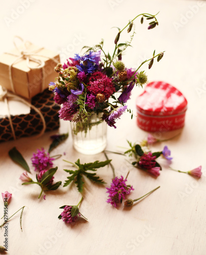 a bouquet of summer flowers  and gifts on the white background