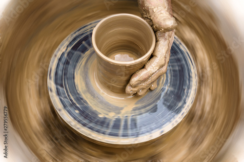 potter's hand mold pottery on a rotating wheel