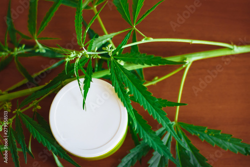 Cannabis hemp cream background with marijuana leaf - cannabis concept self care in of health care. Cosmetics with hemp extract on table. Herbal organic medicine CBD product