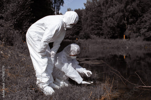 Ecological problem. Pollution. Examine soil. Scientist in protective mask and suit taking water samples from river. Chemist makes an analysis of the environment for radiation. Saving planet earth. ..