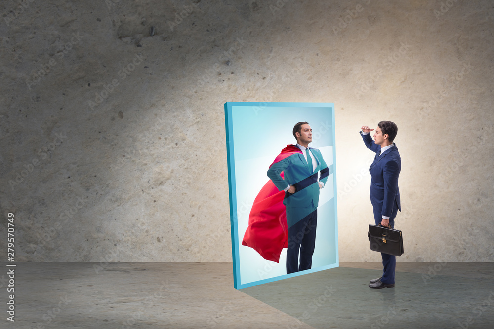 Fototapeta premium Businessman seeing himself in mirror as superhero