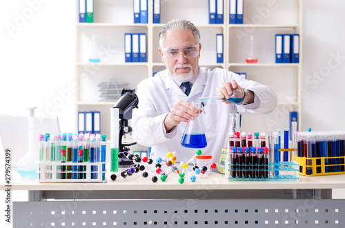 Old male chemist working in the lab