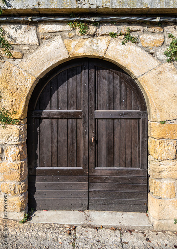 Rustic brown wooden door and stone arch