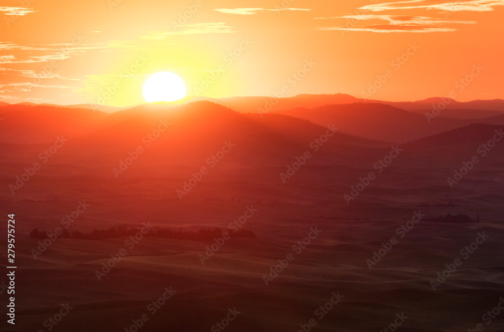 Sun rising over the rolling hills and farm land in palouse, washington