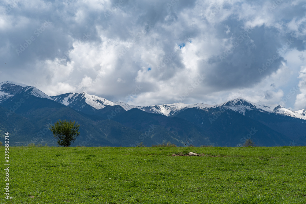 Meadow with background panorama of Pirin mountains near Bansko, Bulgaria