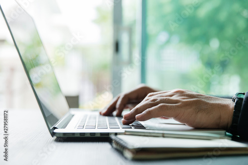 working on laptop, close up of hands of business man working and use smartphone for connection