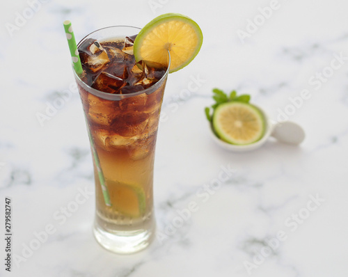 ice tea with lemon mint and ice cubes on white textured background