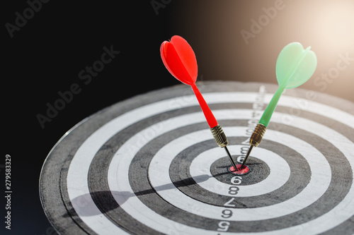 Dart arrow hitting in the target center of dartboard,business target