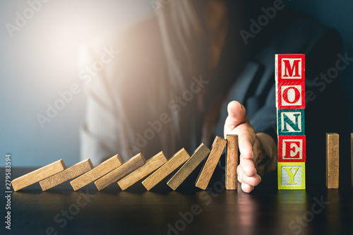 Close up of businessgirl hand Stopping Falling wooden Dominoes effect from continuous toppled or risk, strategy and successful intervention concept for business.