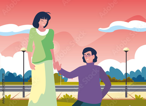 man kneeling with woman holding hand
