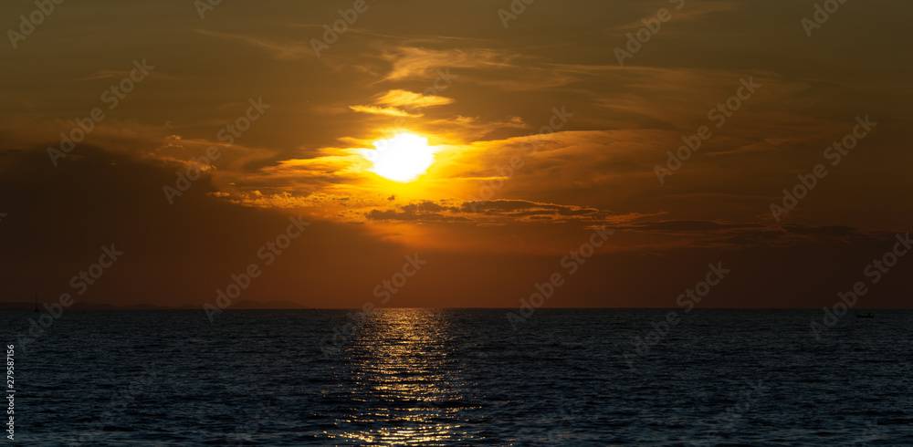 sunset in the sea with clouds in the sky